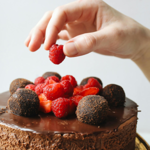 putting berries on the chocolate cake